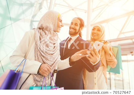 A man in a suit smiles while chatting with a woman 70527647