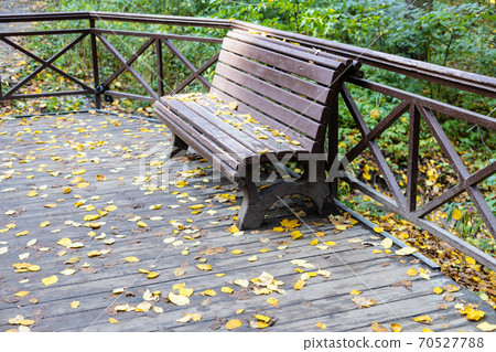 old wooden bench on wooden pavement in park old wooden bench on wooden pavement in park 70527788