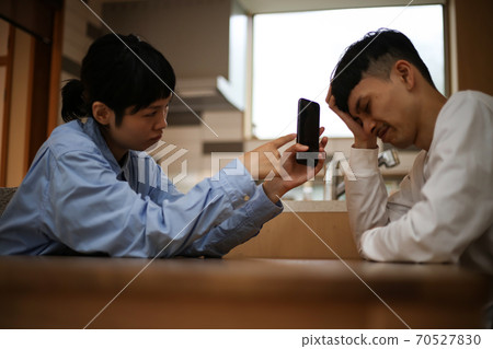 Woman showing smartphone screen to man 70527830