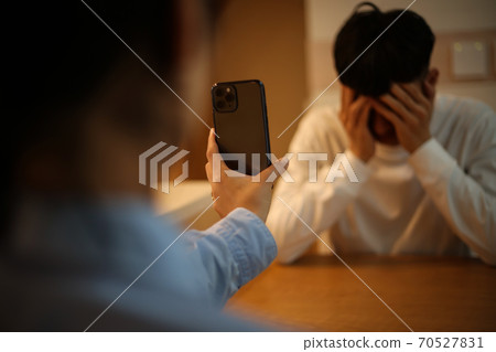 顯示智能手機屏幕的婦女對人 顯示智能手機屏幕的婦女對人 70527831