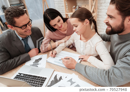 Little girl looks at test while sitting at table. Little girl looks at test while sitting at table. 70527948