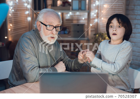 Grandfather and grandson holding hands.  70528307