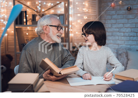 Grandfather with glasses looks at his grandson. Grandfather with glasses looks at his grandson. 70528425