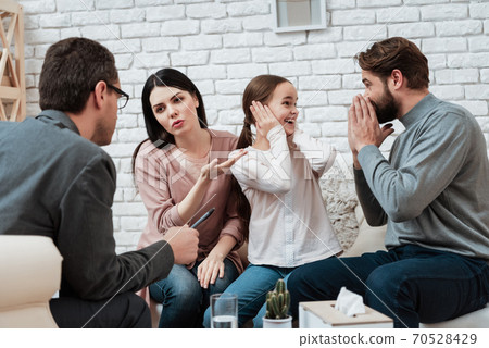 Daughter covers ears and does not listen to dad. 70528429