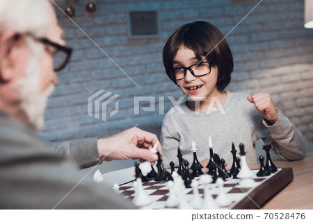 Grandson defeats grandfather who plays chess. 70528476