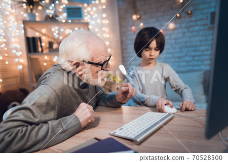 Grandson teaches grandfather to control mouse. 70528500