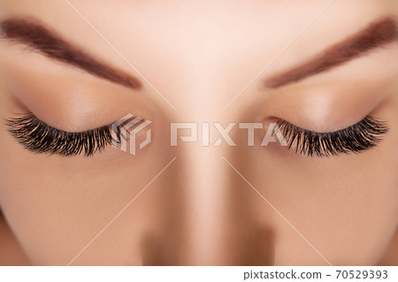 Eyelash Extension Procedure. Woman Eye with Long Eyelashes. Close up, selective focus. Eyelash Extension Procedure. Woman Eye with Long Eyelashes. Close up, selective focus. 70529393