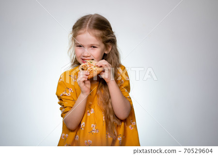 The little girl eating the pizza and laughing. The little girl eating the pizza and laughing. 70529604