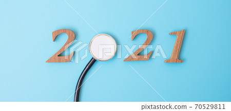 2021 Happy New Year for healthcare, Wellness and medical concept. Stethoscope and wooden number on blue background 2021 Happy New Year for healthcare, Wellness and medical concept. Stethoscope and wooden number on blue background 70529811