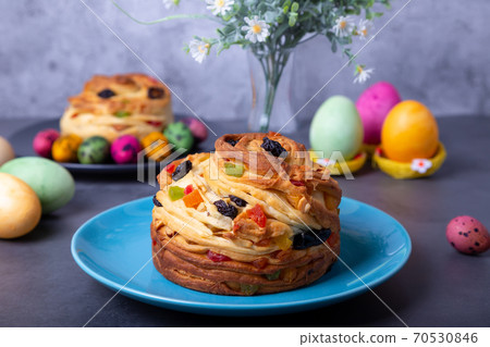 Craffin (Cruffin) with raisins, nuts and candied fruits. Easter Bread Kulich and painted eggs. Easter Holiday. Close-up. Craffin (Cruffin) with raisins, nuts and candied fruits. Easter Bread Kulich and painted eggs. Easter Holiday. Close-up. 70530846