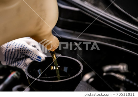 Close-up of oil change in a car during service. 70531031