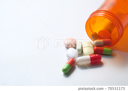 close up of colorful pills spilling on white background close up of colorful pills spilling on white background 70531173
