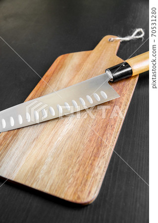Traditional Japanese gyuto knife on a cutting board Traditional Japanese gyuto knife on a cutting board 70531280