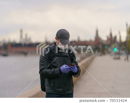 Man wearing protective mask outdoors. Coronavirus pandemic time. Man wearing protective mask outdoors. Coronavirus pandemic time. 70531424
