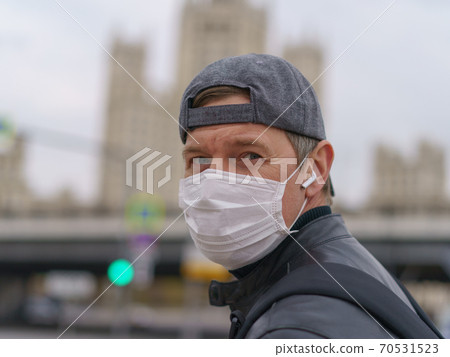 Man wearing protective mask outdoors. Coronavirus pandemic time. Man wearing protective mask outdoors. Coronavirus pandemic time. 70531523