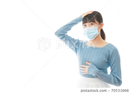 A young woman wearing a mask suffering from poor health 70531666