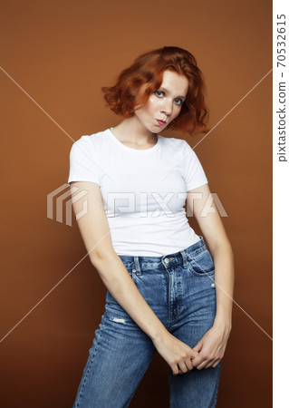 young pretty redhead girl posing cheerful on warm brown background, lifestyle people concept young pretty redhead girl posing cheerful on warm brown background, lifestyle people concept 70532615