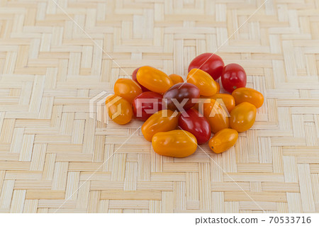 mix of yellow and red tomatoes on a light beige wooden background mix of yellow and red tomatoes on a light beige wooden background 70533716
