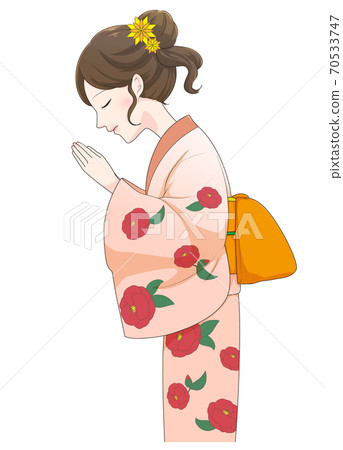 A woman in a kimono praying with her hands together A woman in a kimono praying with her hands together 70533747