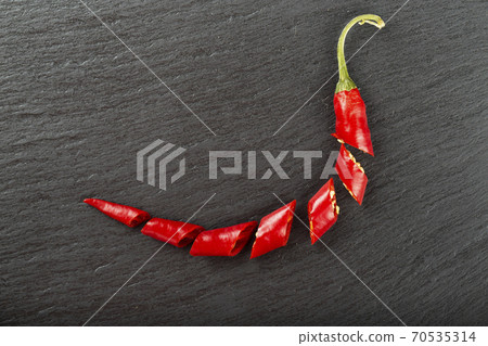 Red chili pepper on a black slate board. Red chili pepper on a black slate board. 70535314