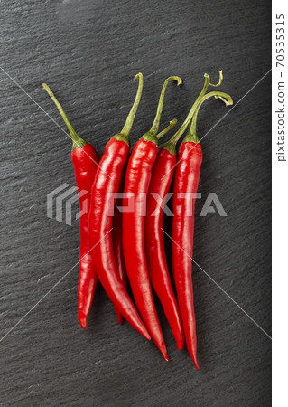 Red chili pepper on a black slate board. Red chili pepper on a black slate board. 70535315