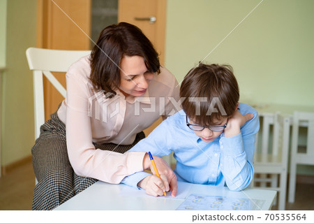 mom helps son to do homework. teacher deals boy. mom helps son to do homework. teacher deals boy. 70535564