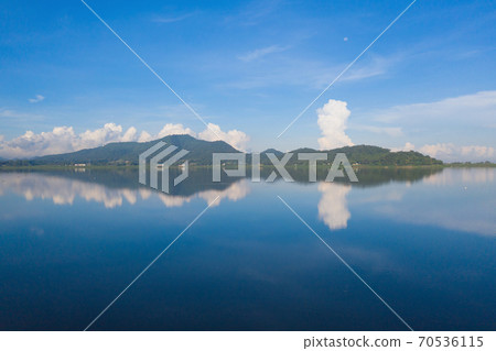 Aerial view of Bang Pra Reservoir dam. National park with reflection of river lake, mountain valley hills at noon and blue sky in Sri Racha, Chonburi, Thailand in travel trip. Natural landscape. Aerial view of Bang Pra Reservoir dam. National park with reflection of river lake, mountain valley hills at noon and blue sky in Sri Racha, Chonburi, Thailand in travel trip. Natural landscape. 70536115