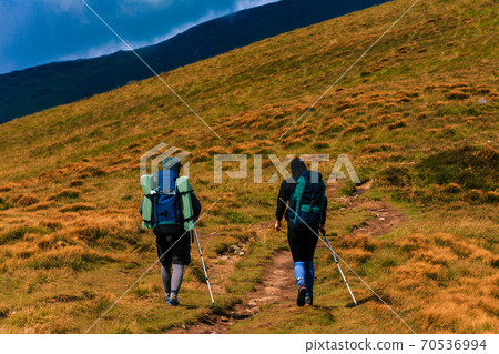 Tourist couple enjoys the views of the Montenegrin ridge, mountain range, Carpathian mountains, tourists in the mountains. Tourist couple enjoys the views of the Montenegrin ridge, mountain range, Carpathian mountains, tourists in the mountains. 70536994