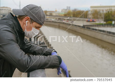 Man wearing protective mask outdoors. Coronavirus pandemic time. Man wearing protective mask outdoors. Coronavirus pandemic time. 70537045