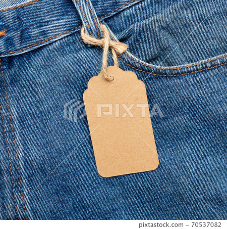 blank brown rectangular tag tied in the back pocket of blue folded jeans 70537082