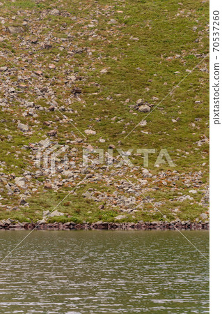 Beautiful and picturesque Carpathian lake Brebeneskul, a guy on the edge of the lake, the edge of the mighty mountains, a lake in the valley. Beautiful and picturesque Carpathian lake Brebeneskul, a guy on the edge of the lake, the edge of the mighty mountains, a lake in the valley. 70537260