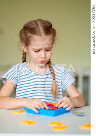 upset little girl solve mathematical puzzle. upset little girl solve mathematical puzzle. 70537266