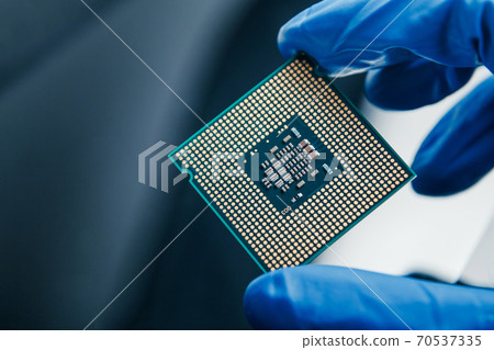 Close-up view on a new semiconductor microchip in gloved hand of computer scientist. Modern technology and hardware development 70537335