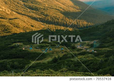 Sunrise in the Carpathians, on the Montenegrin saddle can be seen on the horizon tent camp, tents in the mountains, camping in the Carpathians. Sunrise in the Carpathians, on the Montenegrin saddle can be seen on the horizon tent camp, tents in the mountains, camping in the Carpathians. 70537416