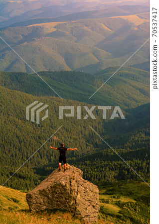 The top of Mount Pip Ivan, a tourist admires the scenery from the top, a hike in the Ukrainian Carpathians, fascinating epic photos. The top of Mount Pip Ivan, a tourist admires the scenery from the top, a hike in the Ukrainian Carpathians, fascinating epic photos. 70537417