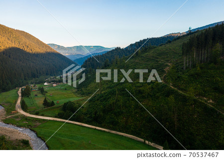 Carpathian river Bila Tisa, the largest tributary of the Danube, Ukrainian mountain river, top view of the river and the road In the village of Luhy. Carpathian river Bila Tisa, the largest tributary of the Danube, Ukrainian mountain river, top view of the river and the road In the village of Luhy. 70537467