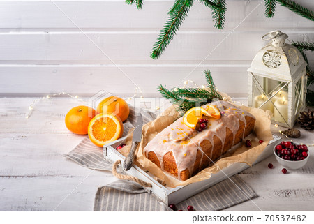 Christmas orange cake with cranberries and sugar icing 70537482
