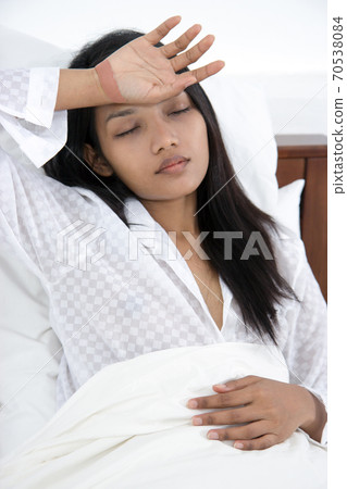A woman resting in bed 70538084