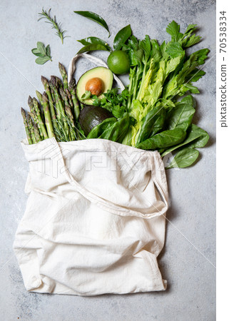 Healthy food ingredients green vegetables and fruits in eco linen bag, zero waste and clean eating concept. gray background Healthy food ingredients green vegetables and fruits in eco linen bag, zero waste and clean eating concept. gray background 70538334