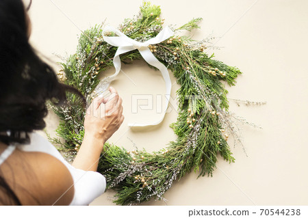 Cute woman decorates advent wreath with her hands 70544238