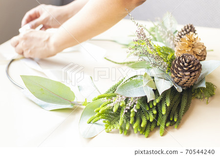 Cute woman decorates advent wreath with her hands 70544240