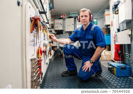 Marine engineer officer in engine control room ECR. He works in workshop Marine engineer officer in engine control room ECR. He works in workshop 70544508