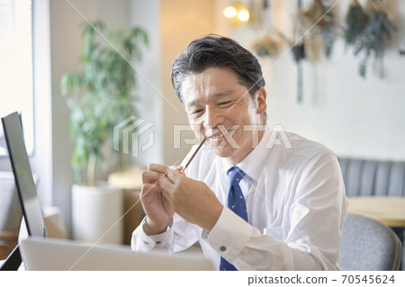 Middle-aged man eating business sweets Middle-aged man eating business sweets 70545624