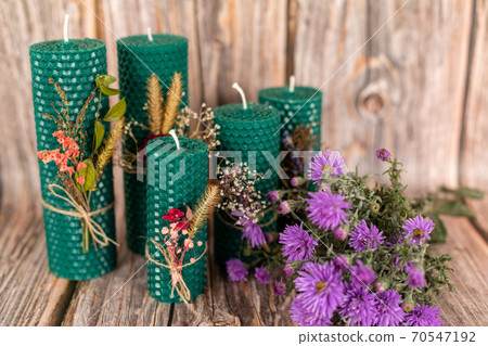 Handmade honey candles made from natural wax on a background of wooden boards. Elements made from natural materials. Christmas or New Year composition. Photo for a postcard. Handmade honey candles made from natural wax on a background of wooden boards. Elements made from natural materials. Christmas or New Year composition. Photo for a postcard. 70547192