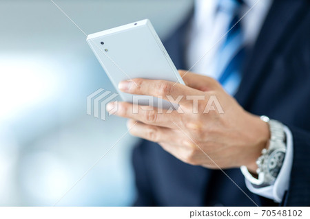 Image of a businessman operating a smartphone Image of a businessman operating a smartphone 70548102