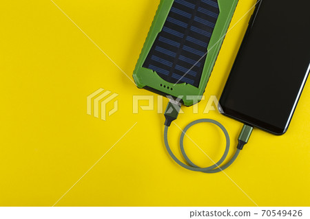 Smartphone Charging with Power Bank on Yellow Background Smartphone Charging with Power Bank on Yellow Background 70549426