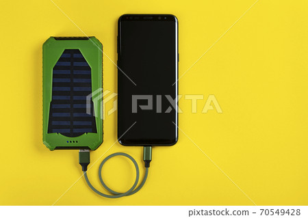 Smartphone Charging with Power Bank on Yellow Background Smartphone Charging with Power Bank on Yellow Background 70549428