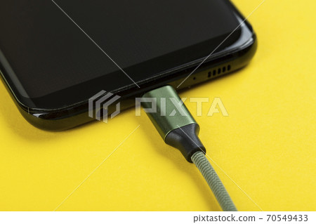 Charging a mobile phone Charging a mobile phone 70549433