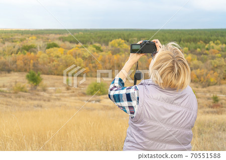 a girl with a camera shoots a landscape a girl with a camera shoots a landscape 70551588