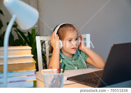 little girl in headphones listens audio lesson  70551836